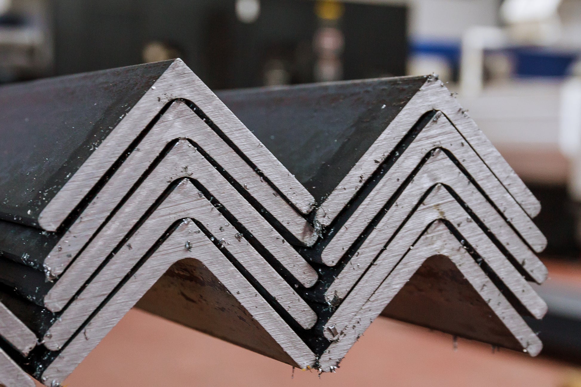 A stack of carbon steel angles with a grayish appearance, indicating a metal surface with metal shavings.